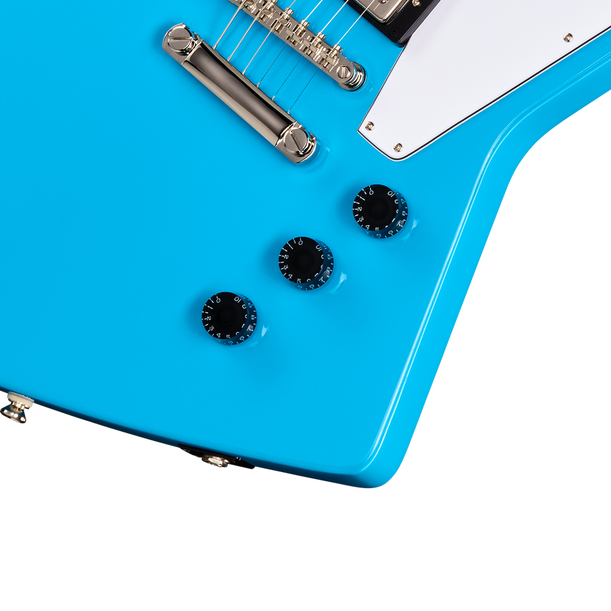 Close-up of a blue electric guitar with white pickguard on a white background