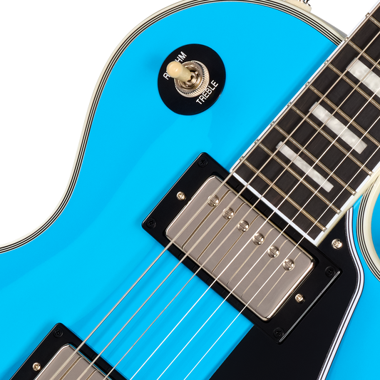 Close-up of a blue electric guitar with a focus on the neck and headstock.
