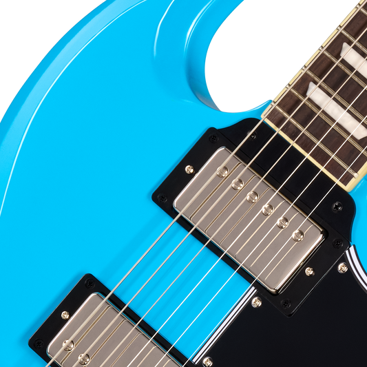Close-up of a bright blue electric guitar body with black pickguards, silver metal hardware, and part of the dark fretboard visible against a white background.