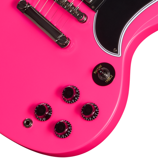 Close-up of a pink electric guitar with control knobs on a white background