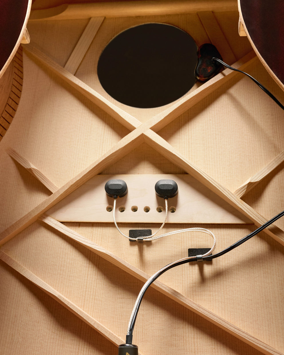 Close-up of the interior of an acoustic guitar with the back cut out, showing the inside, sound hole, and the full Baggs hifi DNA pickup system