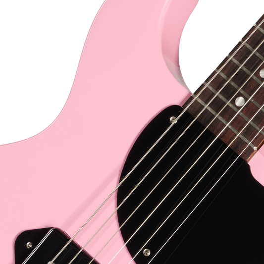 Close-up of a pink electric guitar with a white background