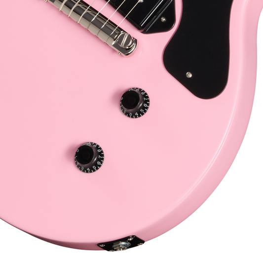 Close-up of a pink electric guitar with a white background