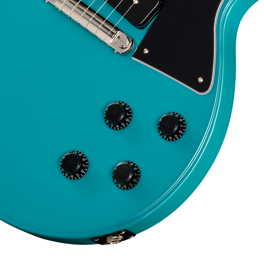Close-up of a turquoise electric guitar with control knobs on a white background
