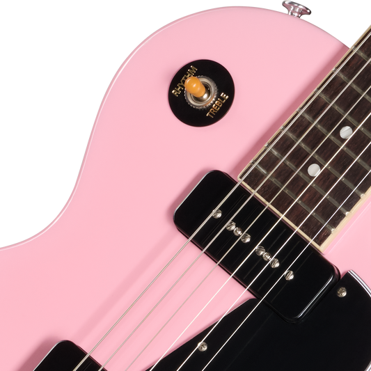 Close-up of a pink electric guitar with a white background