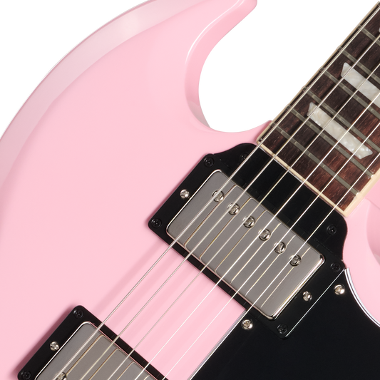Close-up of a pink electric guitar with a white pickguard