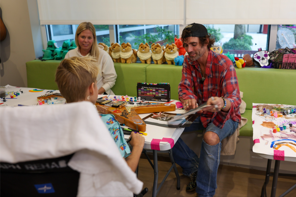 Tyson Ritter of The All-American Rejects painting guitars with patients at Orlando Health Arnold Palmer Hospital for Children in partnership with the Ryan Seacrest Foundation